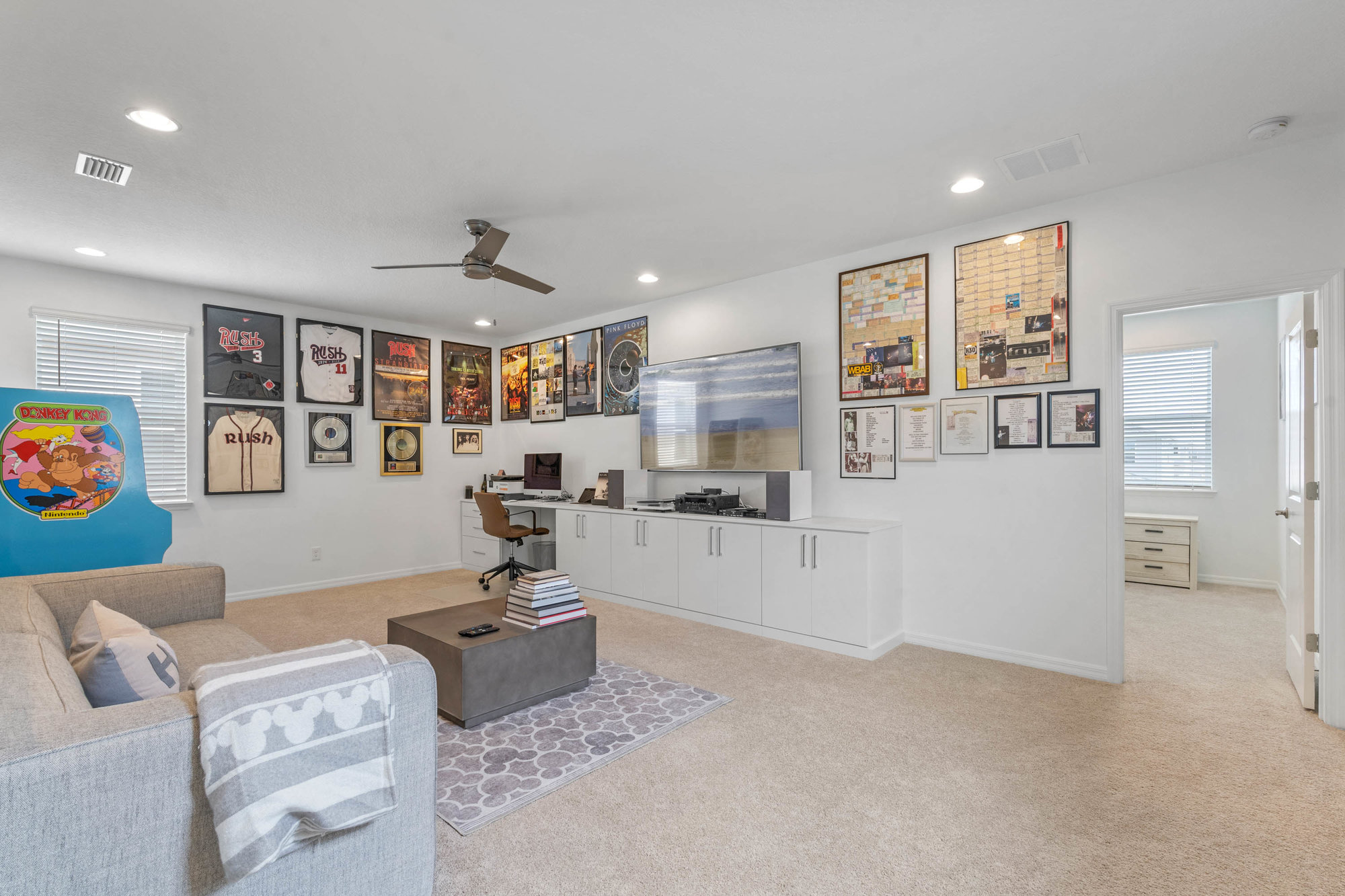 large loft with light carpet and posters on the wall